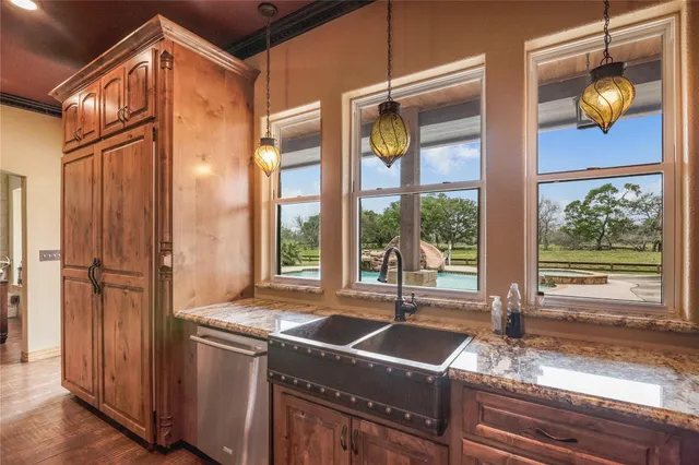 a bathroom with a granite countertop sink and large window