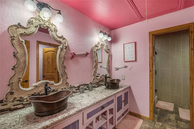 a bathroom with a granite countertop sink a mirror and shower