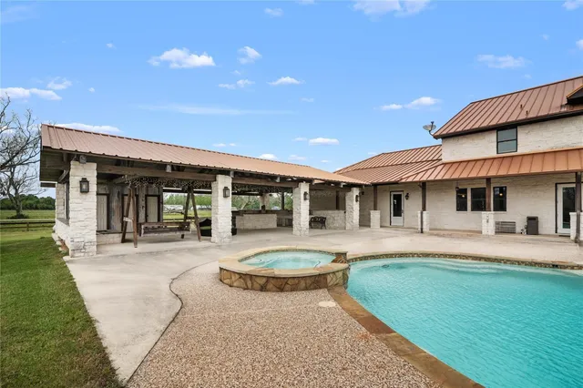 a view of a house with swimming pool and a yard