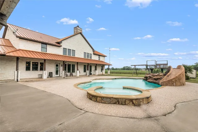 a view of a house with swimming pool and sitting area