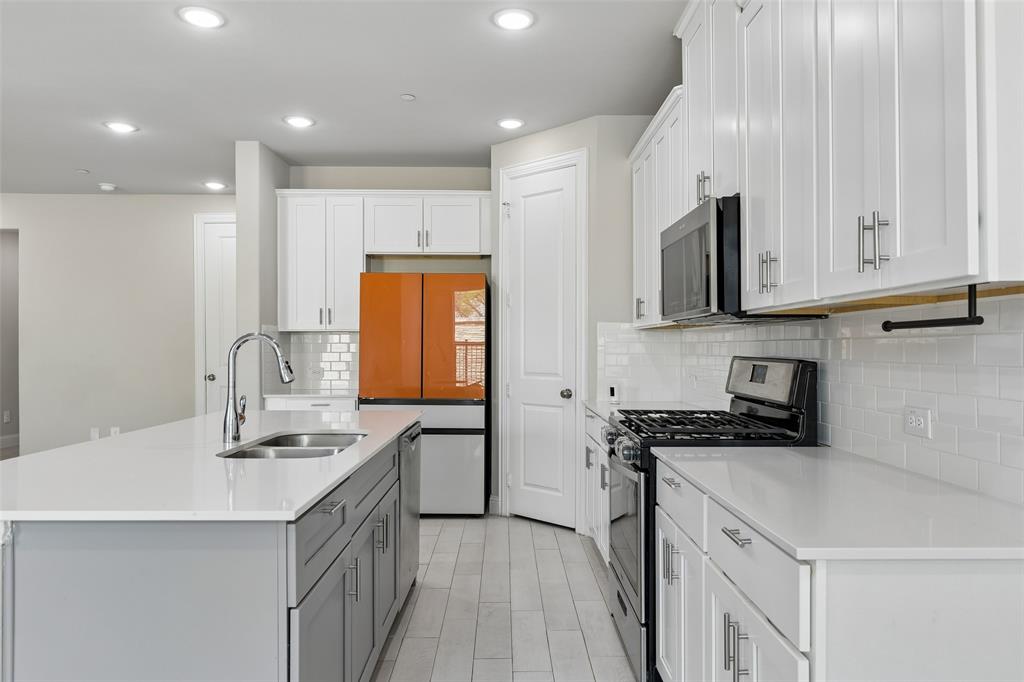 525 Teton Street Allen, TX 75002 - Photo 6 of 31 a kitchen with stainless steel appliances granite countertop a sink stove and cabinets