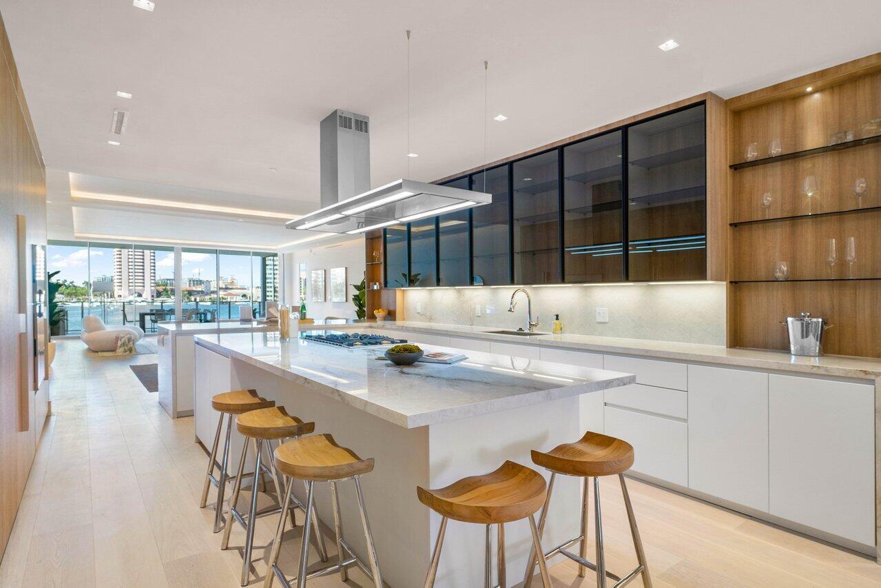 725 South Ocean Boulevard, Unit 202 Boca Raton, FL 33432 - Photo 27 of 57 a kitchen with stainless steel appliances kitchen island granite countertop a table and chairs in it