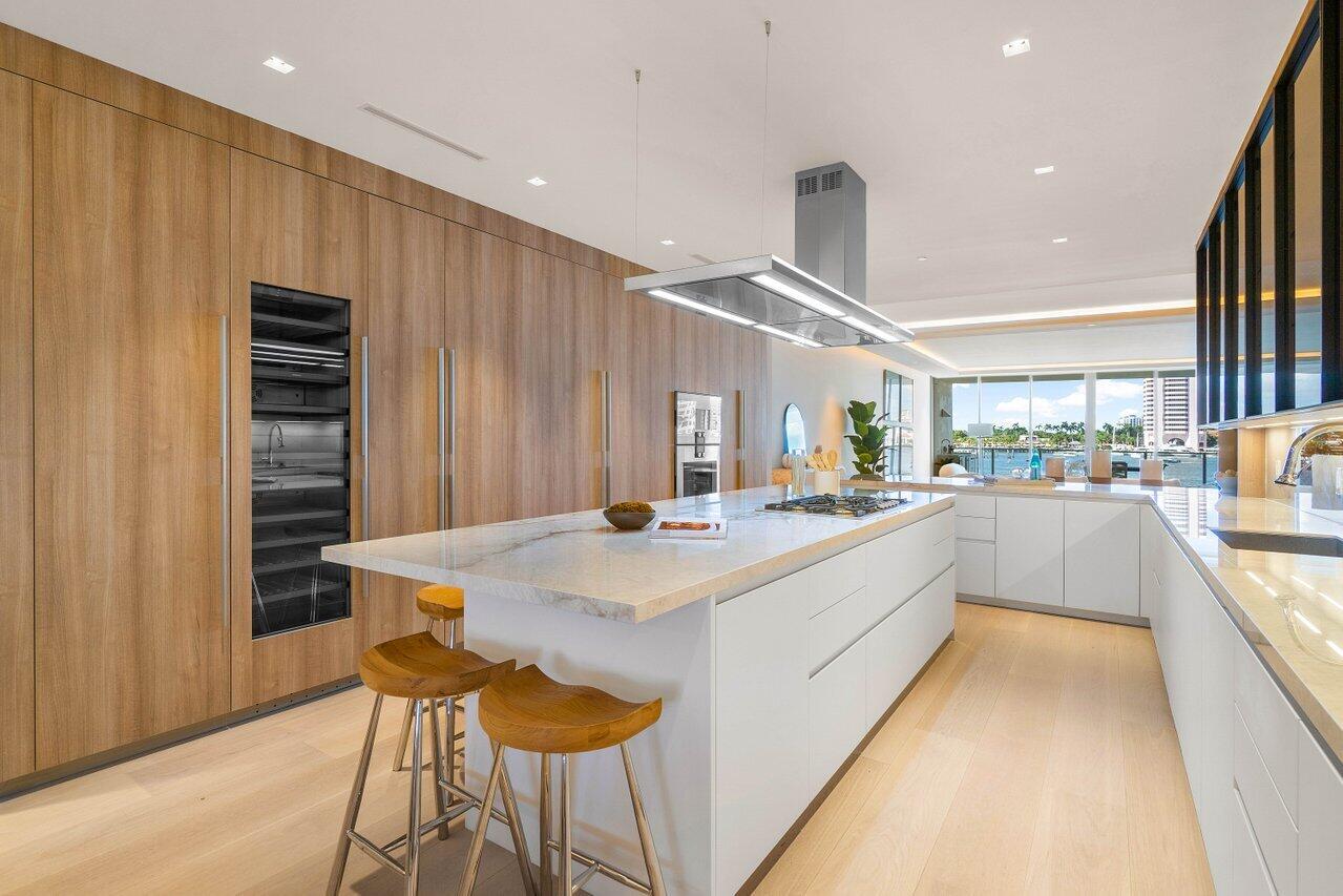 725 South Ocean Boulevard, Unit 202 Boca Raton, FL 33432 - Photo 31 of 57 a large kitchen with kitchen island a stove a table and chairs in it