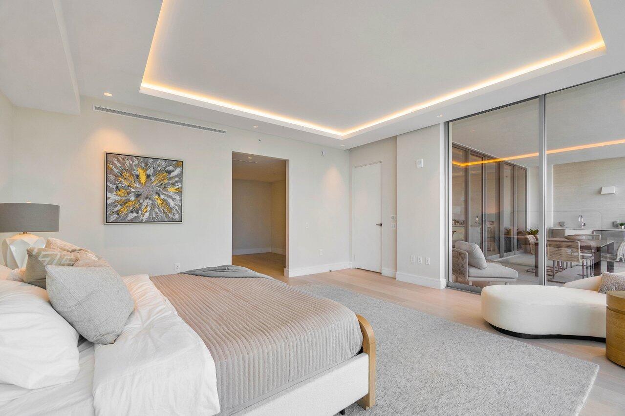 725 South Ocean Boulevard, Unit 202 Boca Raton, FL 33432 - Photo 32 of 57 a bedroom with a large bed and a couch