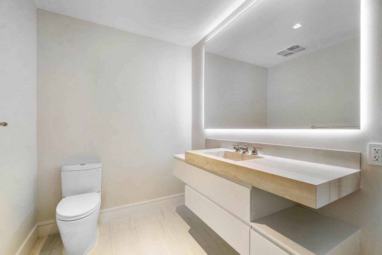 725 South Ocean Boulevard, Unit 202 Boca Raton, FL 33432 - Photo 34 of 57 a bathroom with a granite countertop sink a toilet and a mirror