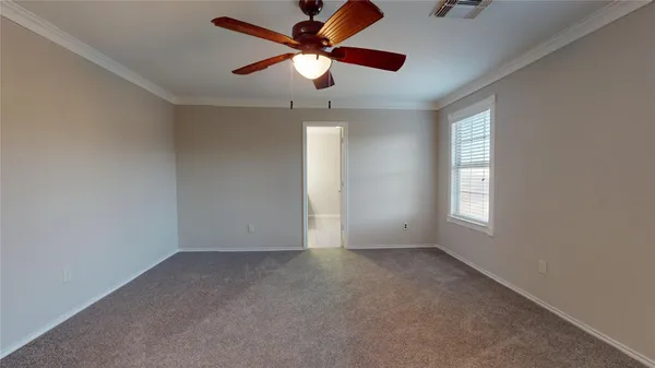 an empty room with a window and a fan