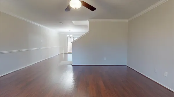 a view of a room with wooden floors and white walls
