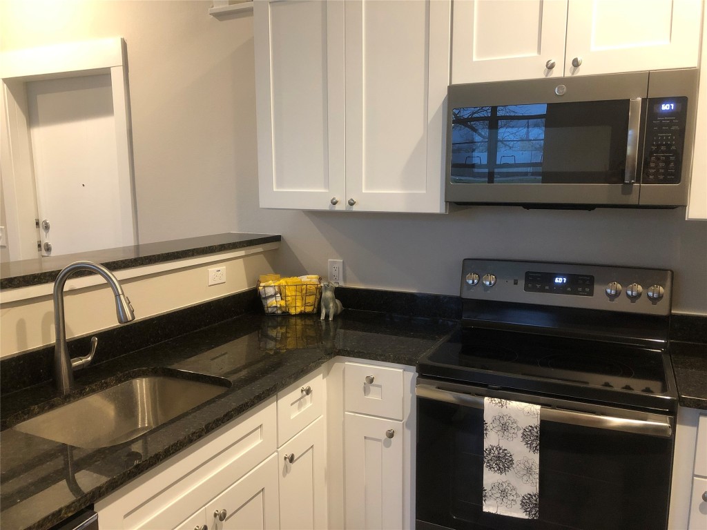 809 Vance Street Taylor, TX 76574 - Photo 4 of 10 a kitchen with stainless steel appliances granite countertop a sink stove and microwave