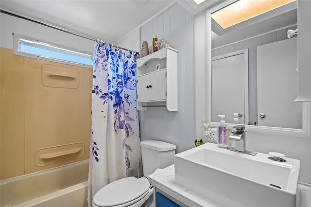 a bathroom with a sink a toilet and shower curtain