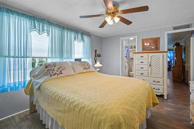 a bed sitting in a spacious bedroom next to a window
