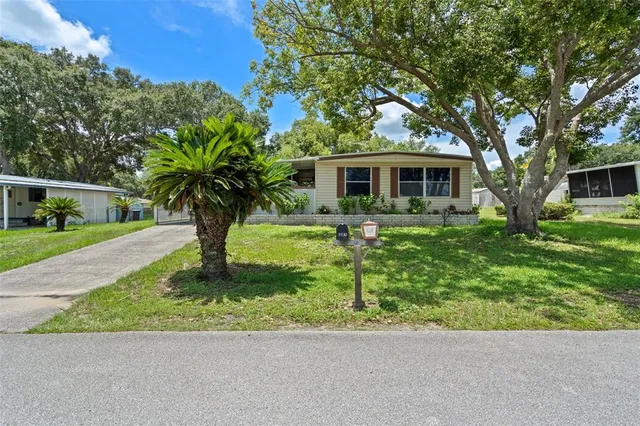a front view of a house with a yard and trees