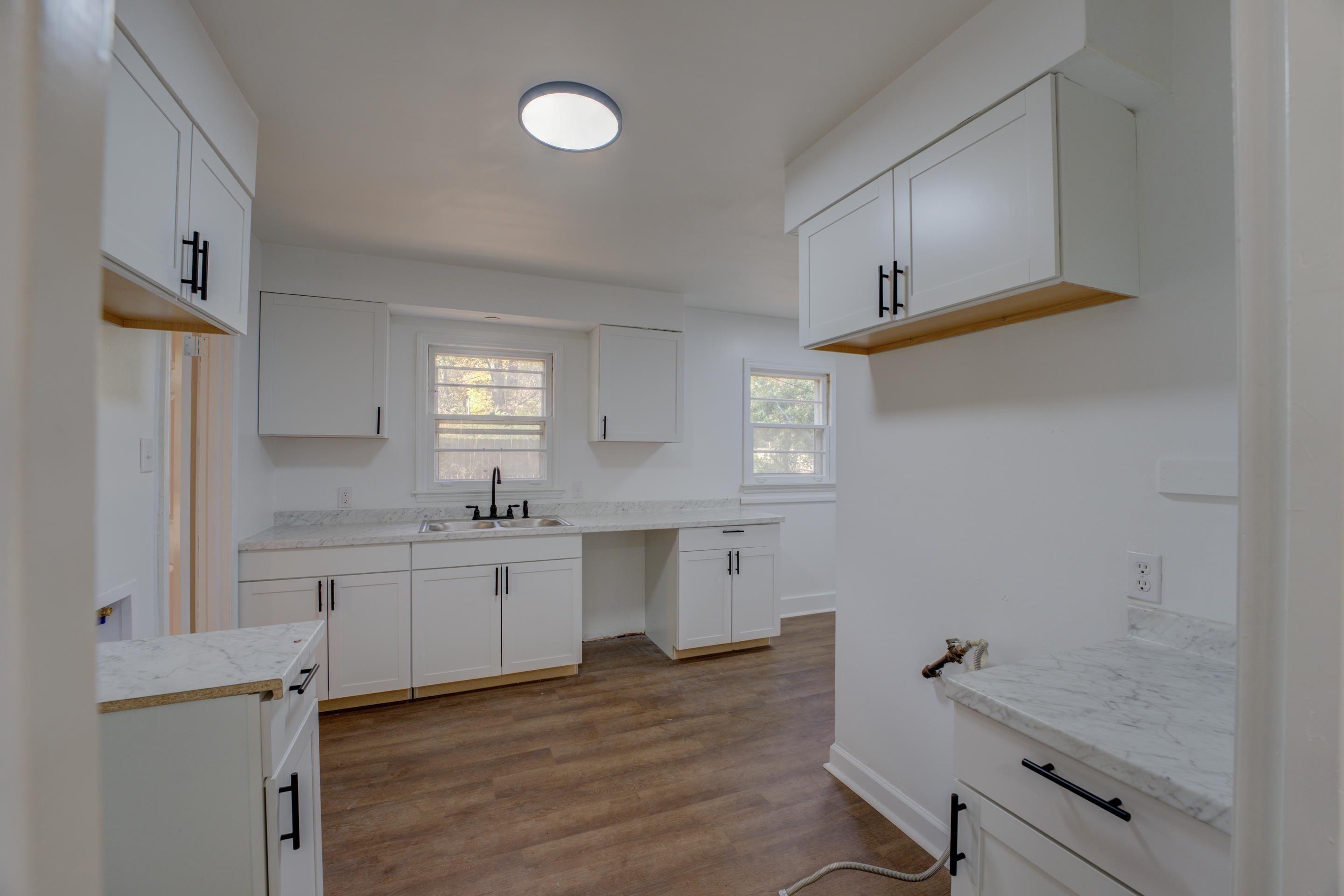 1609 South Perkins Road Memphis, TN 38117 - Photo 9 of 23 a kitchen with a sink dishwasher a stove and white cabinets with wooden floor