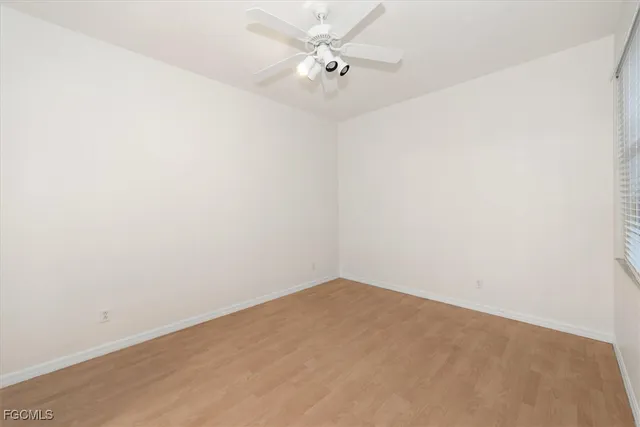 an empty room with a fan & a ceiling fan