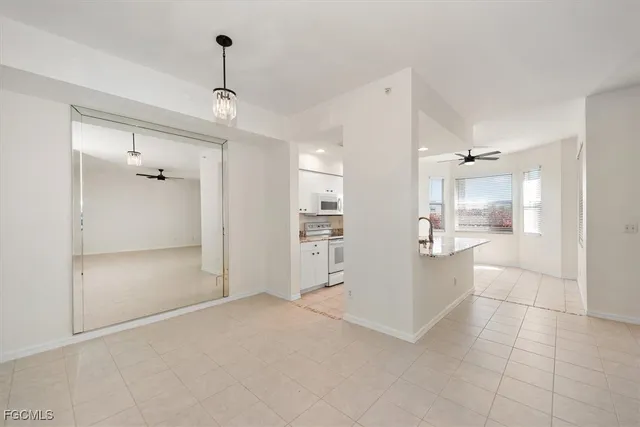 a view of a hallway with wooden floor and a kitchen view