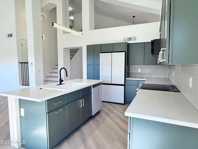 a kitchen with a sink a refrigerator and cabinets