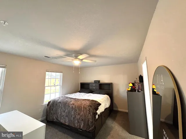 a bedroom with a bed a mirror and a window