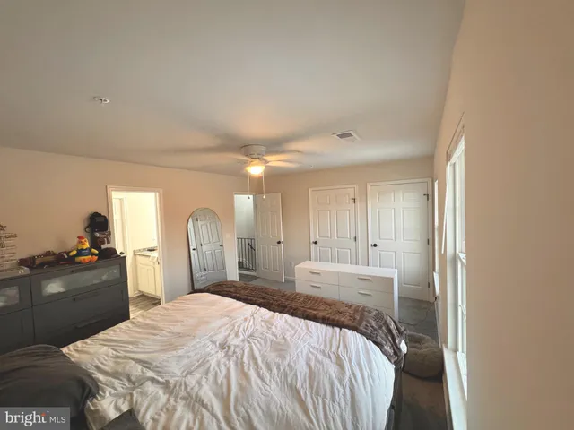 a spacious bedroom with a bed and cabinets