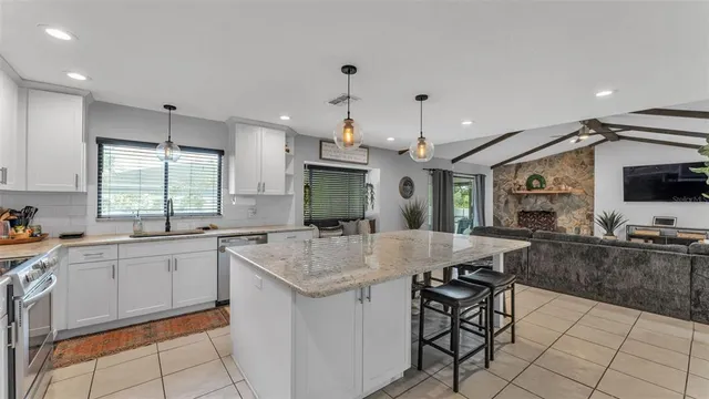 a kitchen with a sink a counter top space appliances and cabinets