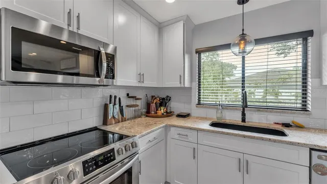 a kitchen with stainless steel appliances a sink a stove a microwave and cabinets