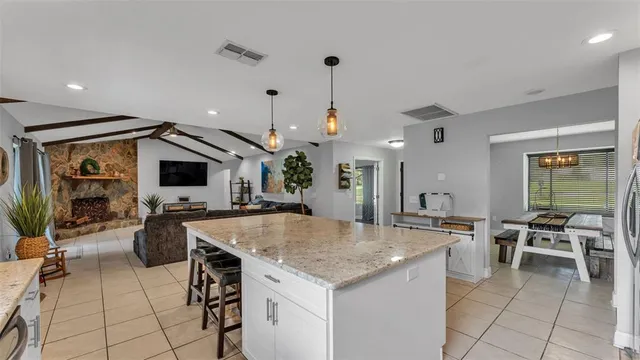 a kitchen with a stove a center island a dining table and chairs