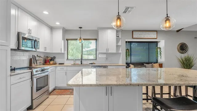 a kitchen with stainless steel appliances granite countertop a sink and stove