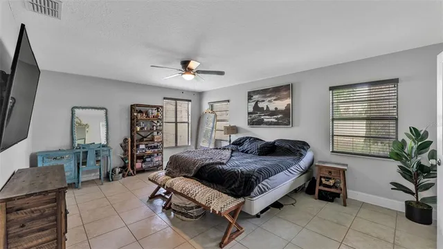 a bedroom with a large bed and a potted plant
