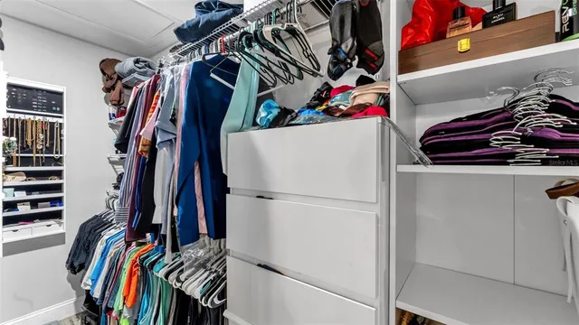 a view of walk in closet with clothes and shoes
