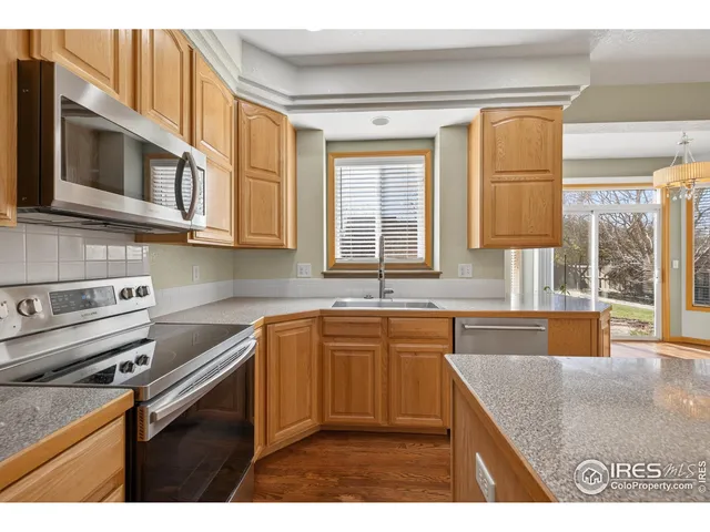 a kitchen with stainless steel appliances granite countertop a sink stove and cabinets