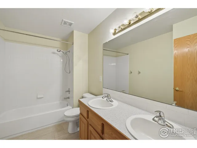 a bathroom with a granite countertop sink toilet a mirror and shower