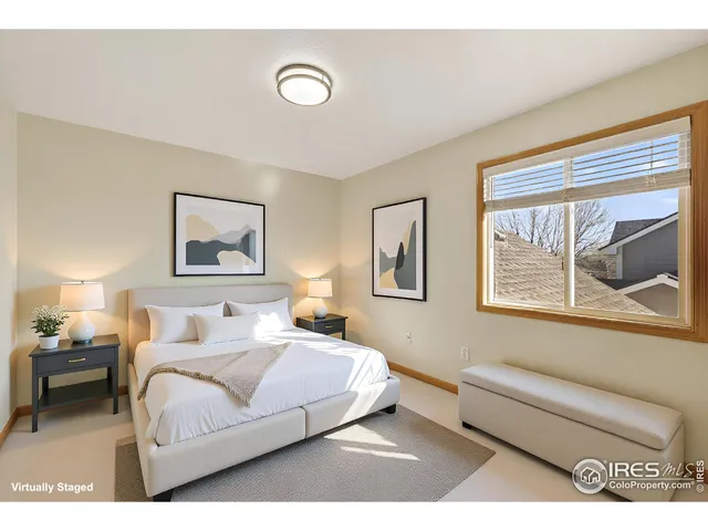 a bedroom with a bed and a painting on the wall