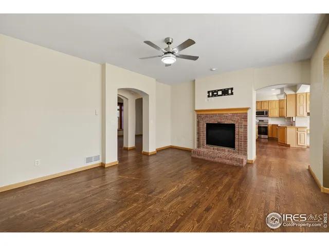 a view of empty room with wooden floor and fireplace
