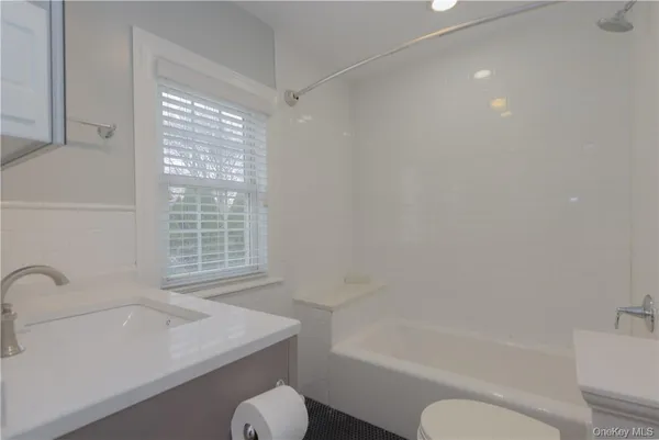 a bathroom with a granite countertop sink toilet and bathtub