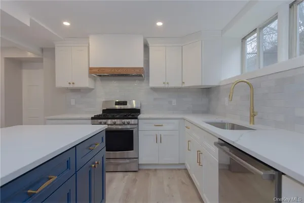 a kitchen with white cabinets stainless steel appliances and sink
