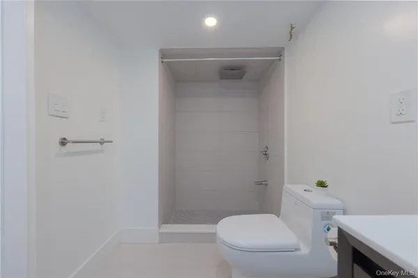 a white toilet sitting next to a shower