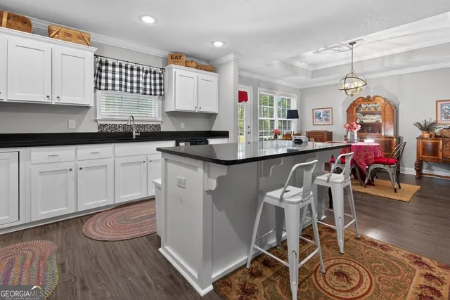 a kitchen with granite countertop white cabinets and a sink