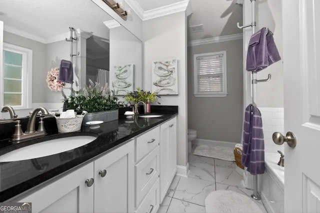 a bedroom with a bed and a flat tv screen on dresser