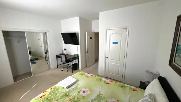 a bed room with a bed tv and a window