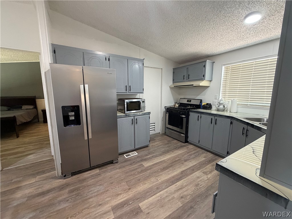 1910 Rio Grande Road Bullhead City, AZ 86442 - Photo 13 of 29 Kitchen featuring wood-finish flooring, stainless steel appliances, gray cabinetry, and a double basin sink