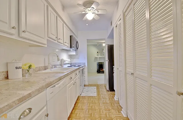 a view of empty room with wooden floor and ceiling fan
