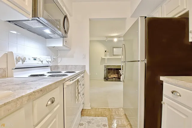 an empty room with chandelier fan and windows