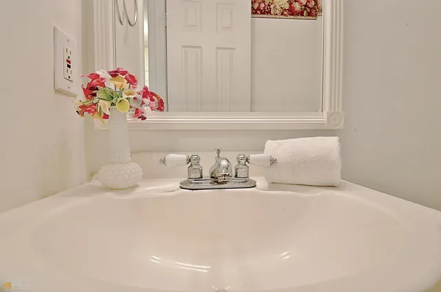 an empty room with potted plants and a chandelier fan