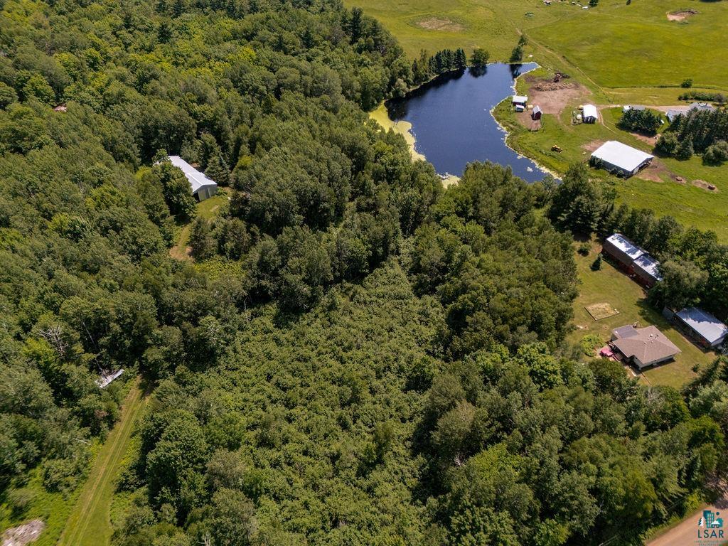 2592 Strandberg Road Barnum, MN 55707 - Photo 11 of 44 Expansive forested acreage featuring a private pond, multiple outbuildings, and a single-story residence with a brown roof