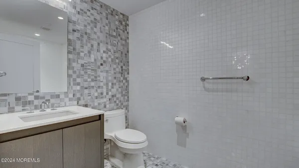 a bathroom with a toilet a sink and mirror