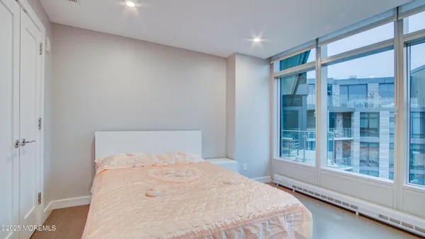 a bedroom with a large window and a balcony