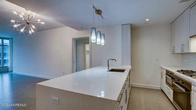 a kitchen with a sink and chandelier