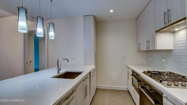 a kitchen with stainless steel appliances a sink stove and cabinets