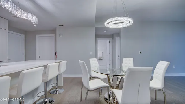 a view of a hallway with wooden floor and a room