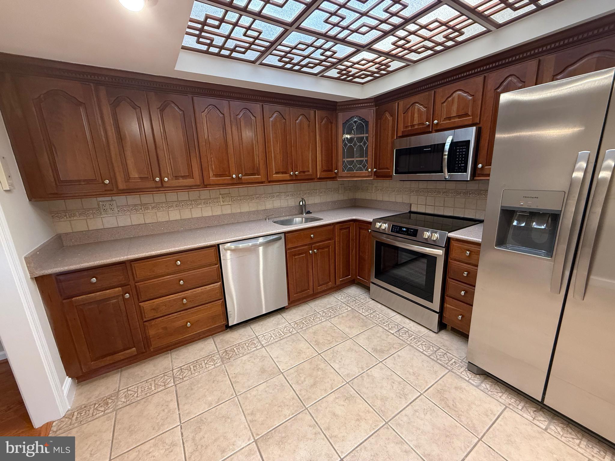 1101 South Arlington Ridge Road, Unit 214 Arlington, VA 22202 - Photo 11 of 41 a kitchen with stainless steel appliances granite countertop wooden cabinets a stove top oven a sink and dishwasher
