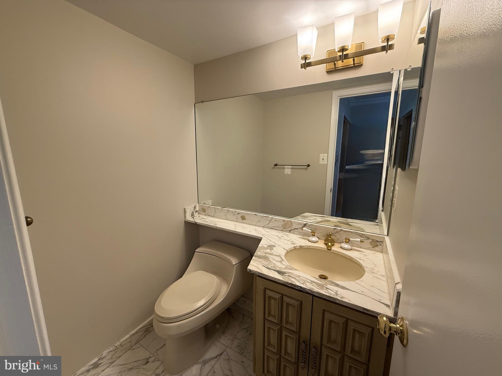 1101 South Arlington Ridge Road, Unit 214 Arlington, VA 22202 - Photo 13 of 41 a bathroom with a granite countertop sink toilet and mirror