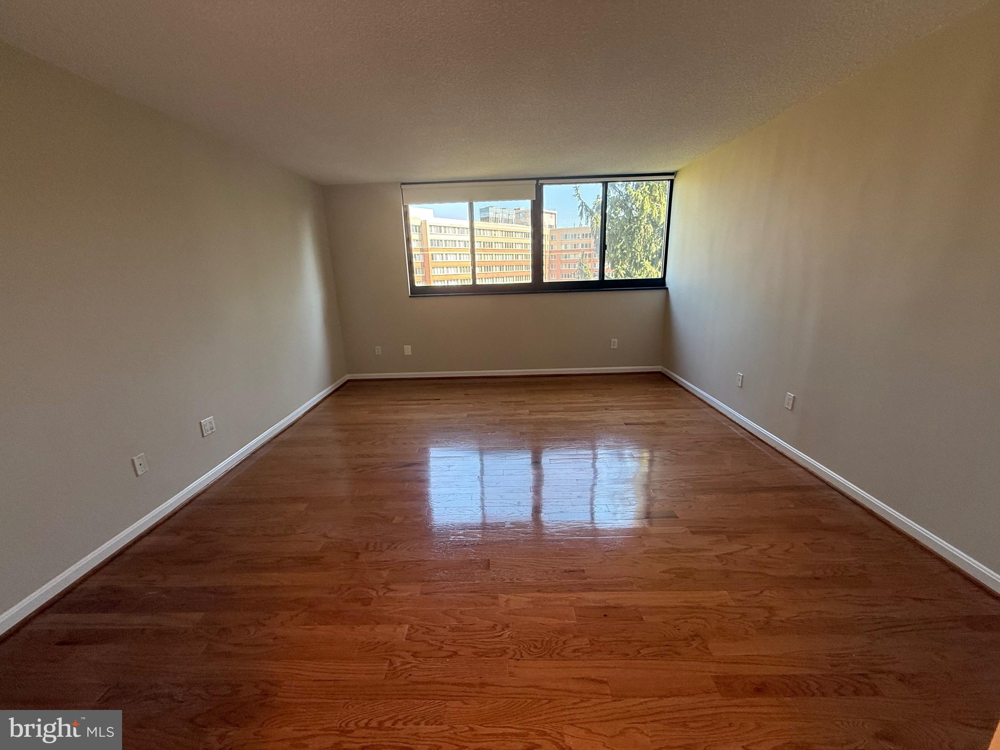 1101 South Arlington Ridge Road, Unit 214 Arlington, VA 22202 - Photo 14 of 41 an empty room with wooden floor and windows